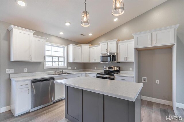 151 Alisha Ave, Poplar Bluff, MO 63901 - kitchen with appliances with stainless steel finishes, a sink, white cabinetry, light wood finished floors, and a center island