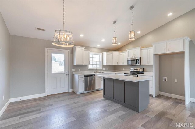 151 Alisha Ave, Poplar Bluff, MO 63901 - kitchen with stainless steel appliances, light countertops, white cabinetry, light wood-style flooring, and a kitchen island