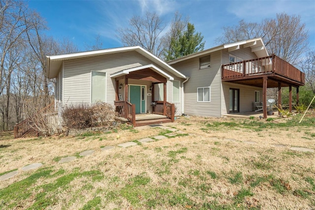 back of property featuring a lawn and a deck
