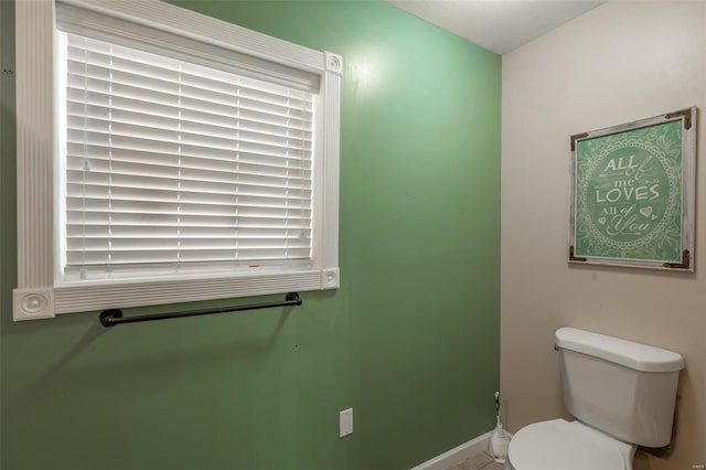 bathroom with toilet and baseboards