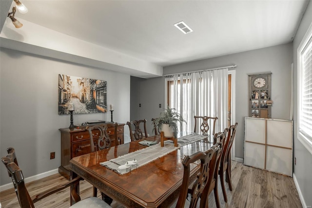 dining room with light wood finished floors, baseboards, and plenty of natural light