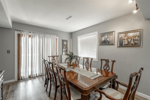 dining area featuring healthy amount of natural light, wood finished floors, and baseboards