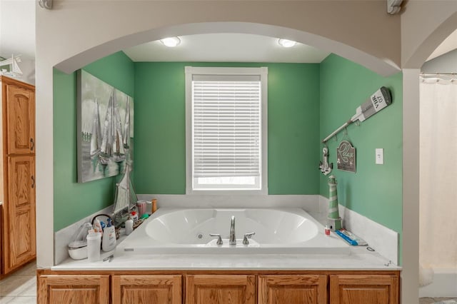 full bath with a tub with jets, plenty of natural light, and tile patterned floors