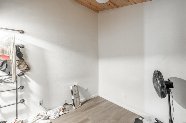 washroom featuring light wood-style flooring, wooden ceiling, and baseboards