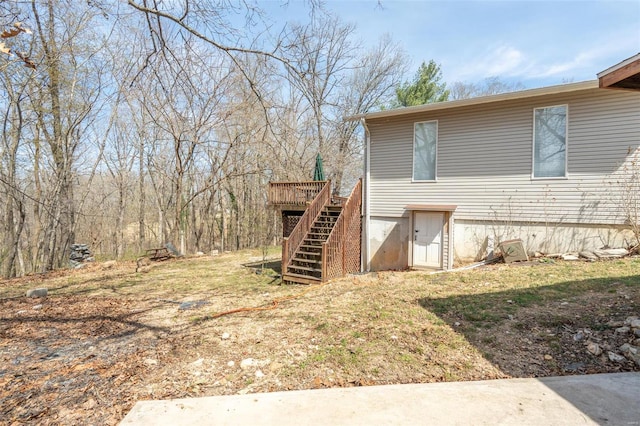 view of home's exterior featuring stairway and a wooden deck