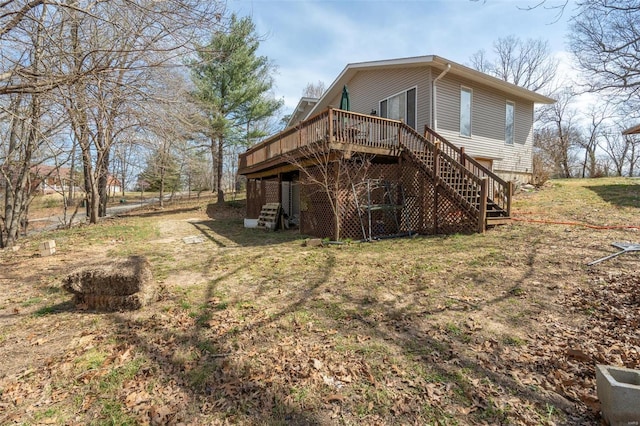 rear view of house with a wooden deck and stairway