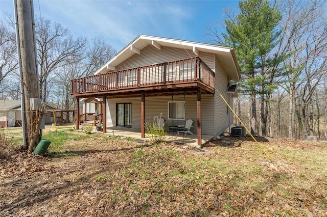 rear view of house with a wooden deck, a patio area, and central AC