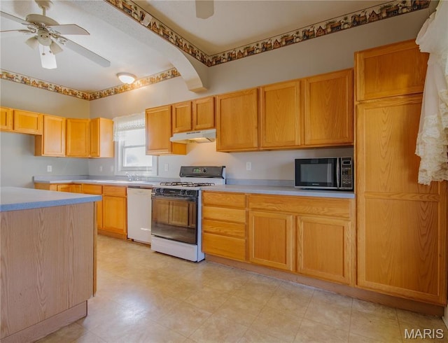 708 E Fillmore St E, Fillmore, IL 62032 - kitchen with gas range oven, white dishwasher, under cabinet range hood, a ceiling fan, and light countertops