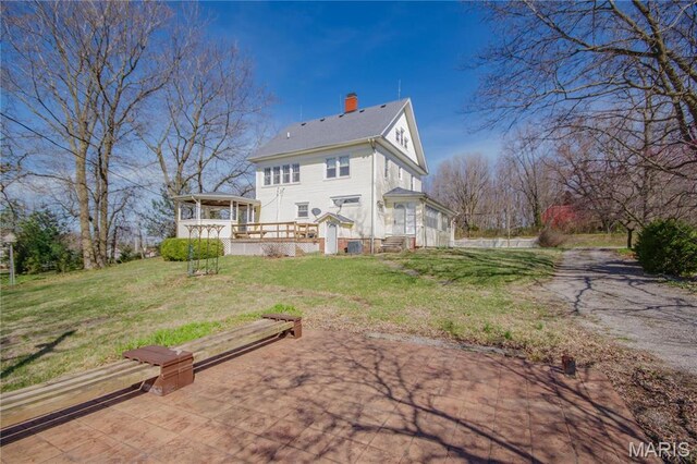 708 E Fillmore St E, Fillmore, IL 62032 - back of house with a chimney, a lawn, a deck, and dirt driveway