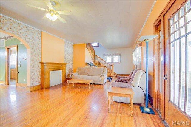 708 E Fillmore St E, Fillmore, IL 62032 - living area featuring wallpapered walls, light wood finished floors, stairway, ceiling fan, and arched walkways