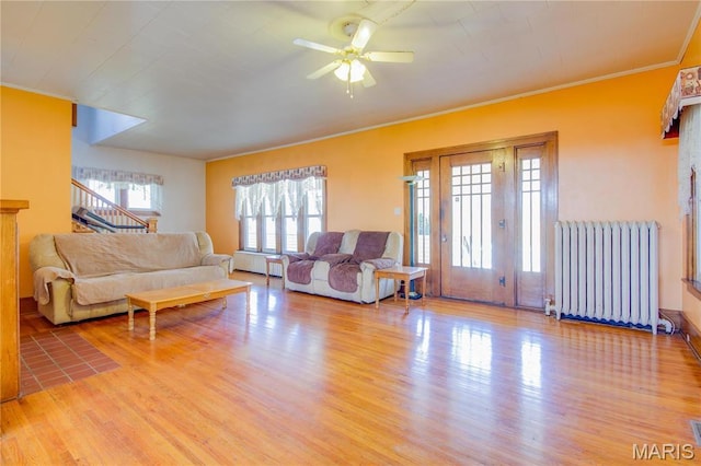 708 E Fillmore St E, Fillmore, IL 62032 - living area with radiator heating unit, wood finished floors, ornamental molding, ceiling fan, and stairs