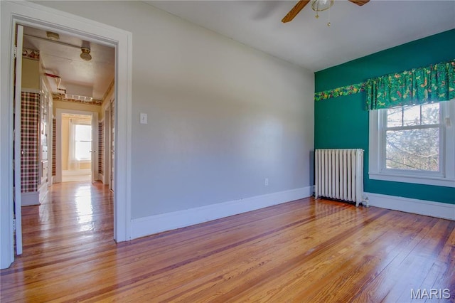 708 E Fillmore St E, Fillmore, IL 62032 - spare room with radiator heating unit, a ceiling fan, light wood-type flooring, and baseboards