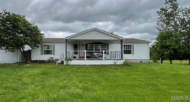 rear view of property with covered porch and a yard