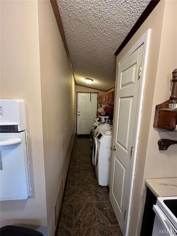 washroom with a textured ceiling and washer and dryer