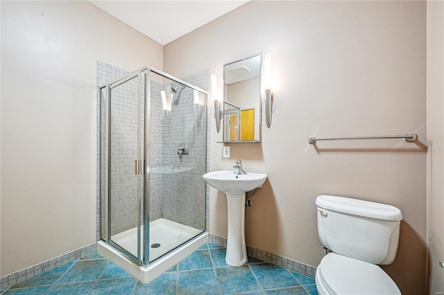 bathroom featuring a stall shower, baseboards, and toilet