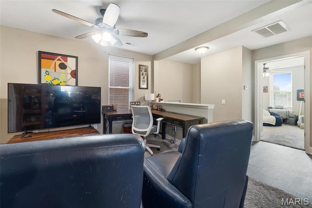 living area with a ceiling fan and an office area