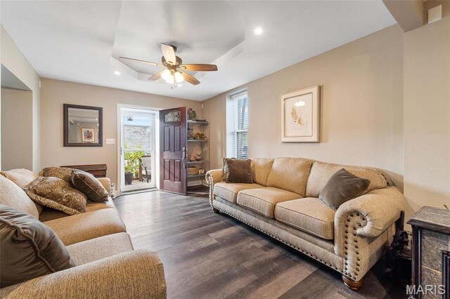 living room with wood finished floors, a ceiling fan, a tray ceiling, and recessed lighting
