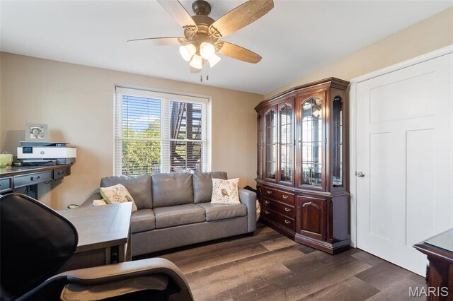 living room featuring dark wood-style flooring and a ceiling fan