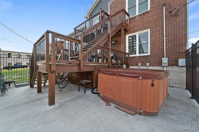 view of patio / terrace with a hot tub, a wooden deck, fence, and stairs