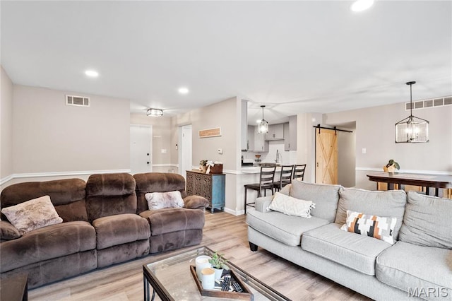 13507 Coliseum Dr Unit F, Chesterfield, MO 63017 - living area with a barn door, light wood finished floors, recessed lighting, and baseboards
