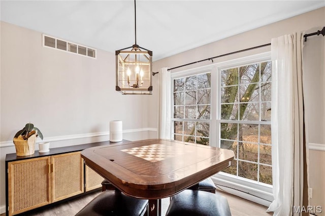 13507 Coliseum Dr Unit F, Chesterfield, MO 63017 - dining room featuring a chandelier, a baseboard radiator, and wood finished floors