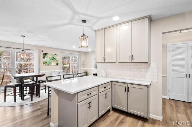 13507 Coliseum Dr Unit F, Chesterfield, MO 63017 - kitchen featuring wood finished floors, gray cabinets, light countertops, backsplash, and recessed lighting