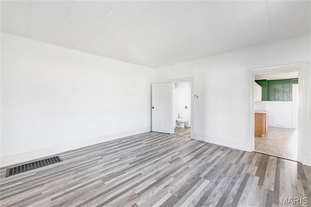 8432 Tennessee Ave, Saint Louis, MO 63125 - unfurnished bedroom featuring wood finished floors, baseboards, and ensuite bathroom