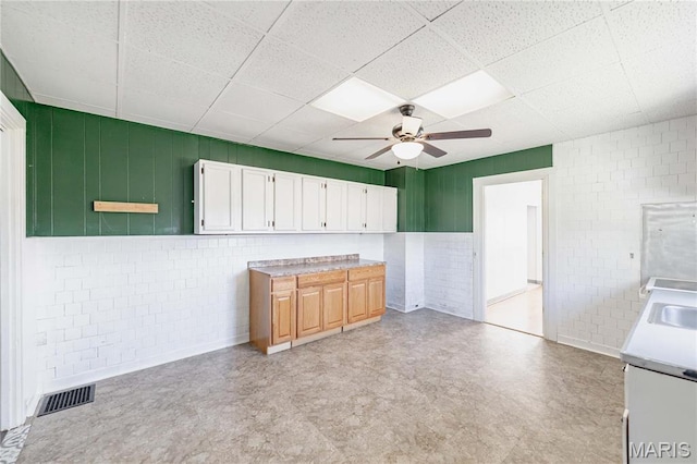 8432 Tennessee Ave, Saint Louis, MO 63125 - kitchen featuring light floors, a drop ceiling, ceiling fan, white cabinetry, and light countertops