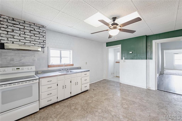 8432 Tennessee Ave, Saint Louis, MO 63125 - kitchen featuring electric range, under cabinet range hood, a sink, light floors, and a drop ceiling