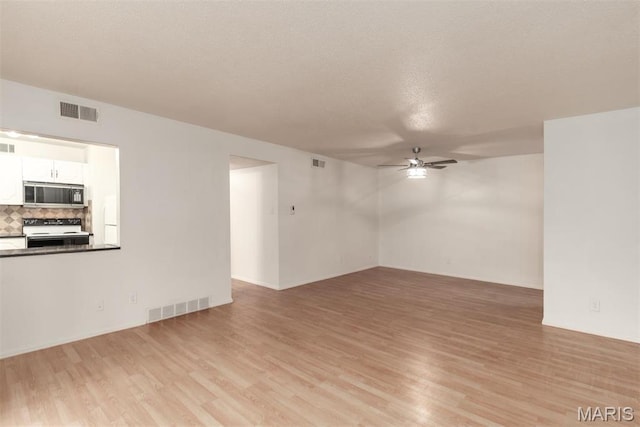13555 Coliseum Dr Unit G, Chesterfield, MO 63017 - unfurnished living room featuring a ceiling fan, light wood-type flooring, and a textured ceiling
