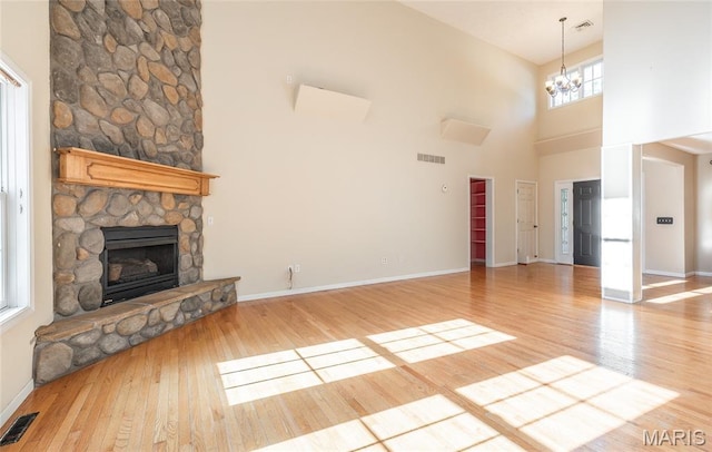 10625 Pine Needle Cir, Rolla, MO 65401 - unfurnished living room with a high ceiling, light wood-style flooring, a fireplace, a chandelier, and baseboards