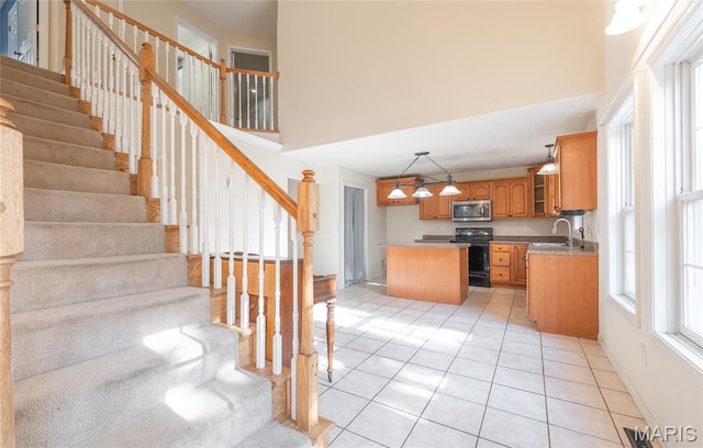 10625 Pine Needle Cir, Rolla, MO 65401 - kitchen featuring stainless steel microwave, black / electric stove, a kitchen island, a sink, and a towering ceiling