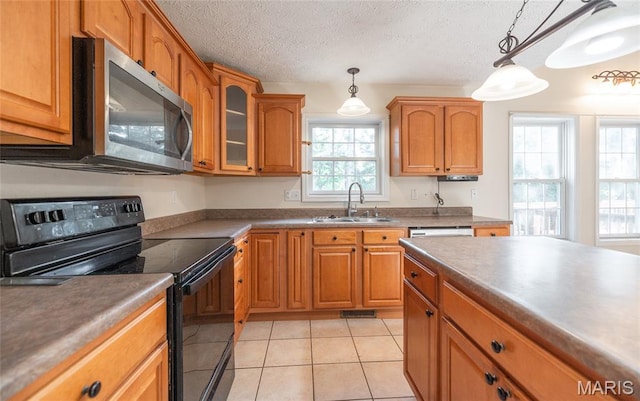 10625 Pine Needle Cir, Rolla, MO 65401 - kitchen featuring stainless steel appliances, a sink, brown cabinets, and a textured ceiling