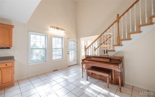 10625 Pine Needle Cir, Rolla, MO 65401 - entryway with high vaulted ceiling, light tile patterned floors, stairs, and baseboards