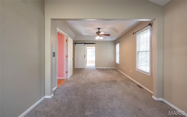 10625 Pine Needle Cir, Rolla, MO 65401 - empty room with carpet, a ceiling fan, a barn door, and baseboards