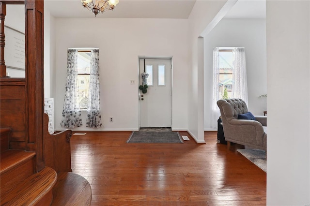 3944 Russell Blvd, Saint Louis, MO 63110 - entrance foyer with hardwood / wood-style flooring, a chandelier, baseboards, and stairs
