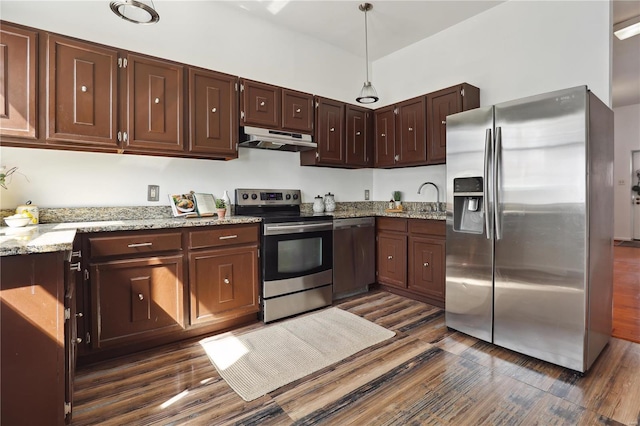 3944 Russell Blvd, Saint Louis, MO 63110 - kitchen featuring appliances with stainless steel finishes, under cabinet range hood, dark wood-type flooring, and light stone counters