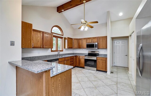 kitchen featuring stainless steel appliances, a sink, brown cabinetry, high vaulted ceiling, and a peninsula