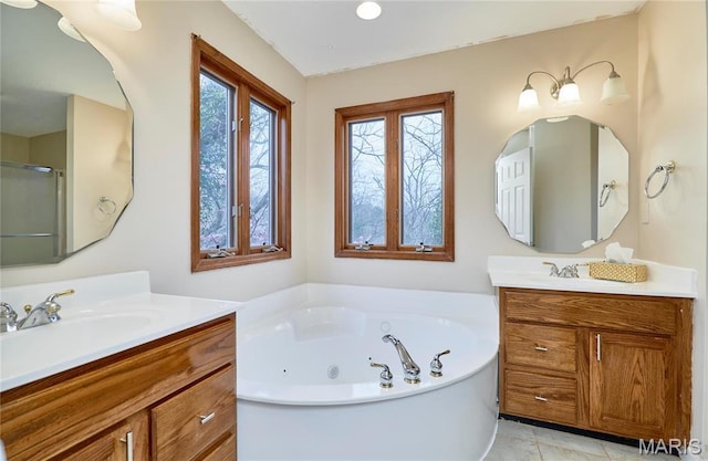 bathroom featuring a tub with jets, two vanities, and a shower with shower door