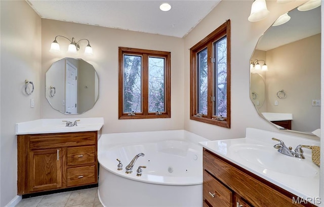 full bath with a tub with jets, two vanities, and tile patterned flooring