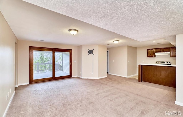 unfurnished living room featuring light carpet, baseboards, and a textured ceiling
