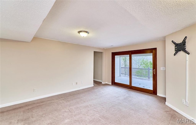 unfurnished room with carpet floors, a textured ceiling, and baseboards