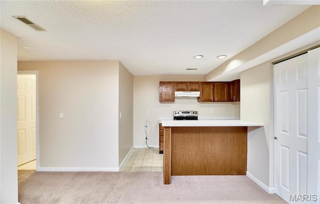 kitchen featuring under cabinet range hood, electric stove, light carpet, light countertops, and baseboards