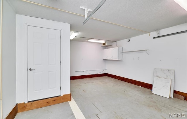 finished basement featuring baseboards and a textured ceiling