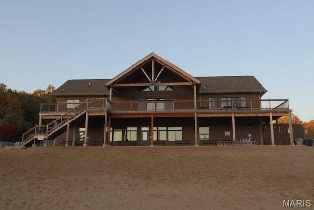 rear view of house featuring stairway and a wooden deck