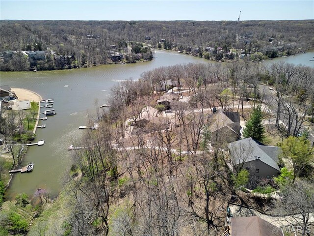 aerial view of property's location with a heavily wooded area and a nearby body of water
