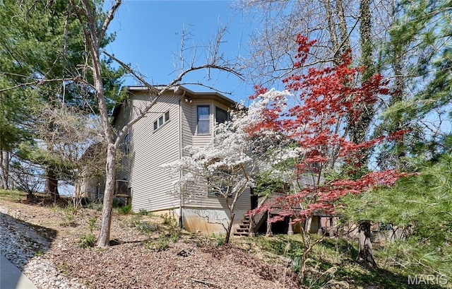 view of property exterior featuring stairway and a wooden deck