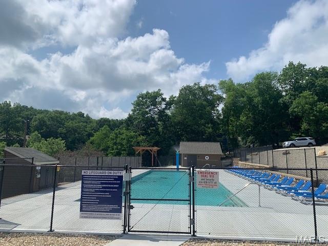 view of pool with a gate and fence