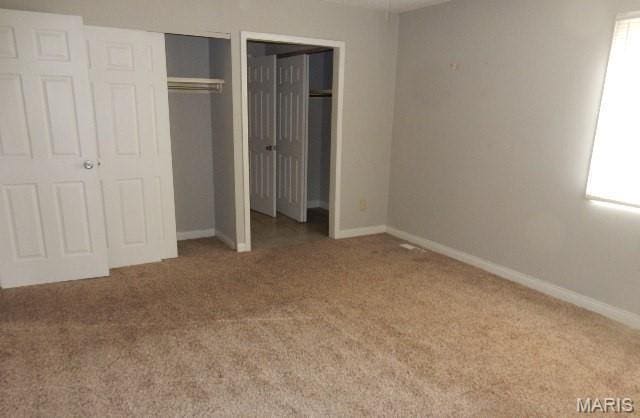 12654 Treeyard Ln, Saint Louis, MO 63138 - unfurnished bedroom with carpet flooring, baseboards, and multiple closets