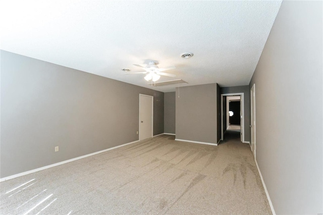 spare room with a ceiling fan, light carpet, and baseboards